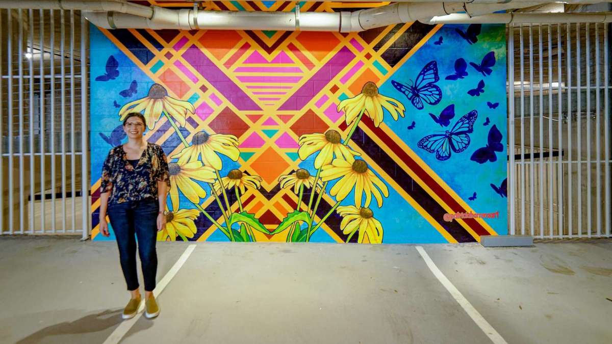 Houston artist Patricia Barrera poses with one of three murals she has created for the garage entrance of Drewery Place, Caydon USA's first highrise apartment building in Midtown.
